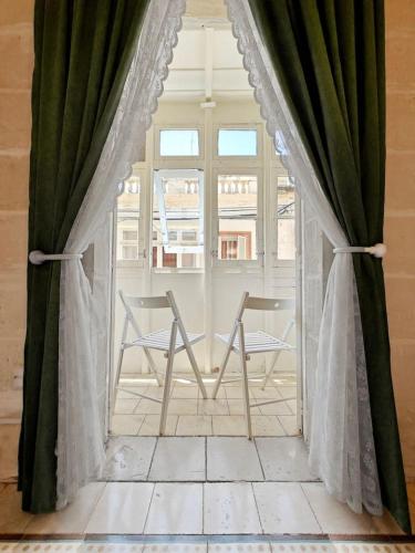 a room with two chairs and a window at Casa Maltija Sliema 4 Bedroom in Sliema