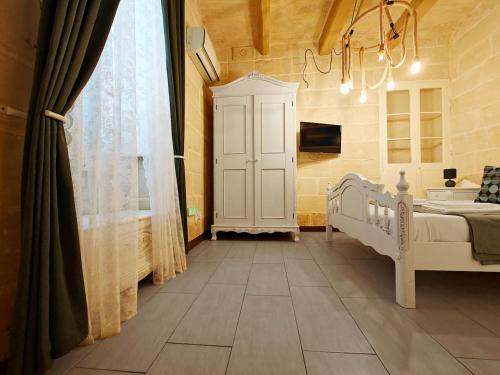 a bedroom with a white bed and a window at Casa Maltija Sliema 4 Bedroom in Sliema