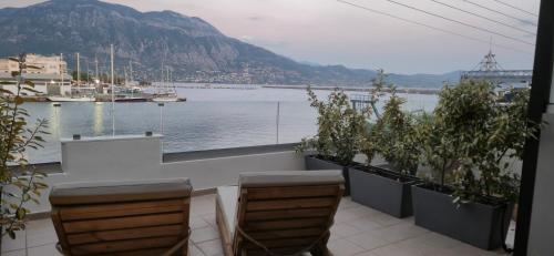a balcony with chairs and a view of the water at Thalori Suites in Kalamata