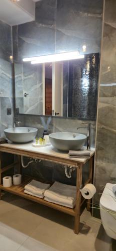 a bathroom with two sinks and a mirror at Thalori Suites in Kalamata