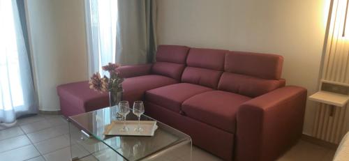 a living room with a red couch and a glass table at Thalori Suites in Kalamata
