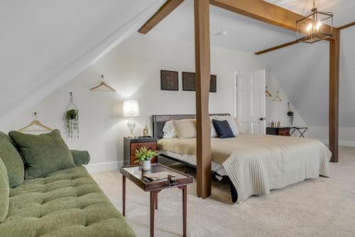 a bedroom with a bed and a couch at Spacious Luxe Condo in Historic Downtown Wolfeboro in Wolfeboro