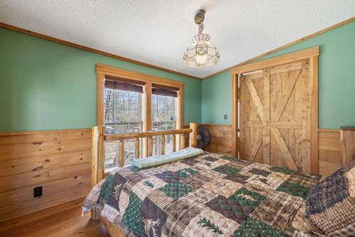 a bedroom with a bed and a wooden door at Cozy 3BR with Firepit and Boat Slip Option in Moultonborough