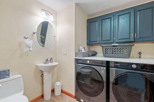 a bathroom with a washing machine and a sink at 3BR with Hot Tub Arcade Games Near Lake and Slopes in Gilford