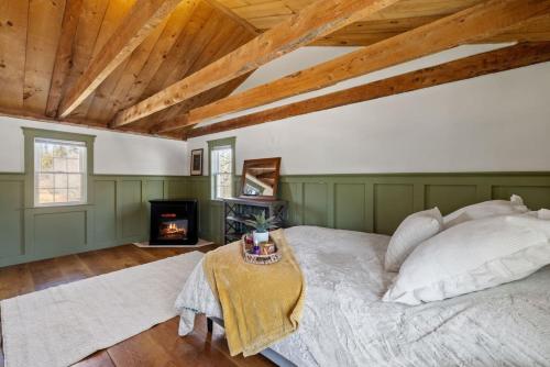 a bedroom with a bed and a fireplace at Rustic Beauty, Fireplace, Cows & Mountain Views in Gilmanton