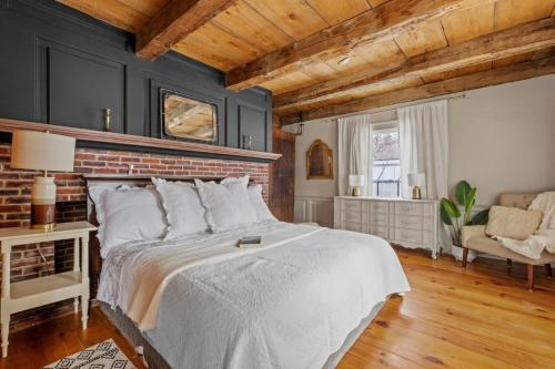 a bedroom with a bed and a brick wall at Private Farm Loft - Tub, Animals & Pasture Views in Gilmanton
