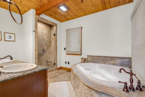 a large bathroom with a tub and a sink at Peekaboo Lake View Luxury 5BR with Game Room in Gilford