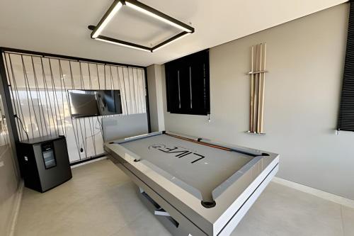Habitación con mesa de ping pong y TV. en Studio Encanto no Santa Maria., en Uberlândia