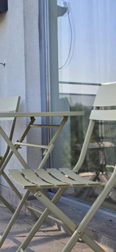 a white chair sitting in front of a window at Runo Apartamenty - komfort i widok w centrum miasta in Sanok