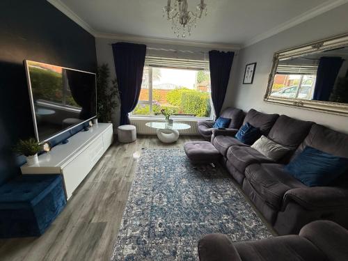 a living room with a couch and a flat screen tv at Room at quiet location close to Belfast in Carnmoney
