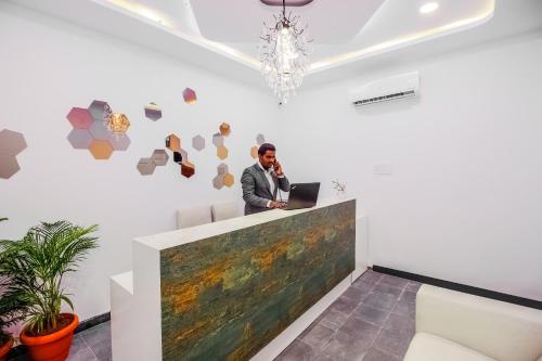 a man sitting at a desk with a laptop at Hotel O D' Jade in Hyderabad