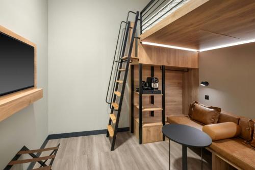 a tiny house with a loft bed and a living room at Moxy London Piccadilly Circus in London