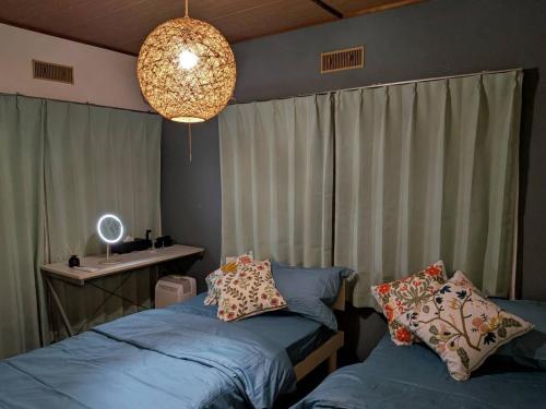 a bedroom with two beds and a table and a chandelier at Kyoto Fushimi Yado - Vacation STAY 19114 in Kyoto