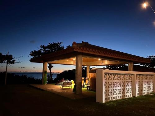 ein Pavillon mit einem Zaun in einem Hof bei Nacht in der Unterkunft Umisora Resort Uminoie - Vacation STAY 92021v in Tokeshi