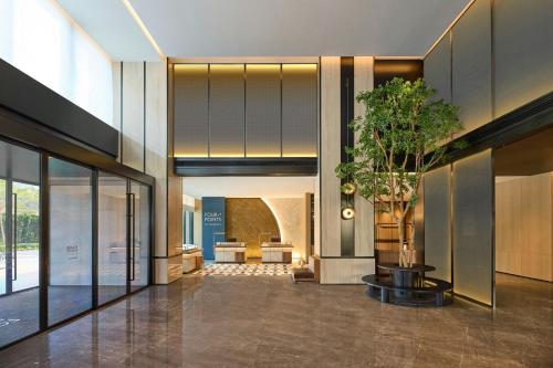 a lobby with a tree in the middle of a building at Four Points by Sheraton Nanning, Wuxiang in Nanning