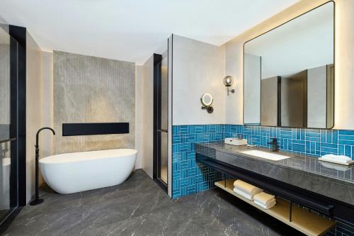 a bathroom with a tub and a large mirror at Four Points by Sheraton Nanning, Wuxiang in Nanning
