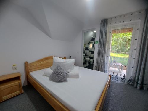 ein Schlafzimmer mit einem großen weißen Bett und einem Fenster in der Unterkunft Casa Ioana in Poiana Mărului