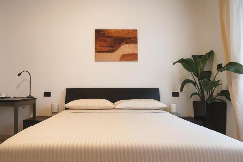 a bedroom with a bed and a potted plant at Camere private Lingotto-Mirafiori Rooms in Turin