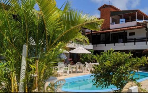 a resort with a swimming pool and palm trees at Pousada Luz do Porto in Porto De Galinhas