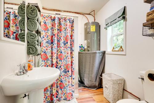 un baño con lavabo y ducha en Woodsy and Charming! Tiny Cottage with Yard in Pelkie, en White