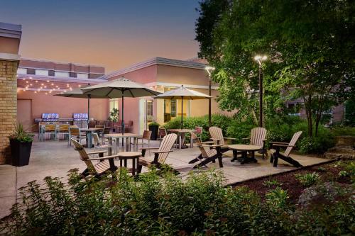 an outdoor patio with tables and chairs and umbrellas at TownePlace Suites by Marriott Mississauga-Airport Corporate Centre in Mississauga