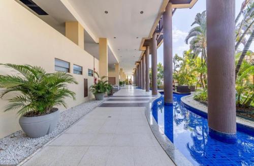 a hallway of a building with a swimming pool at Barra Bali Resort in Barra de São Miguel