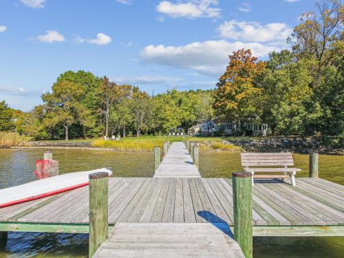a wooden dock with two benches on a lake at Bankors Aweigh in Mount Pleasant