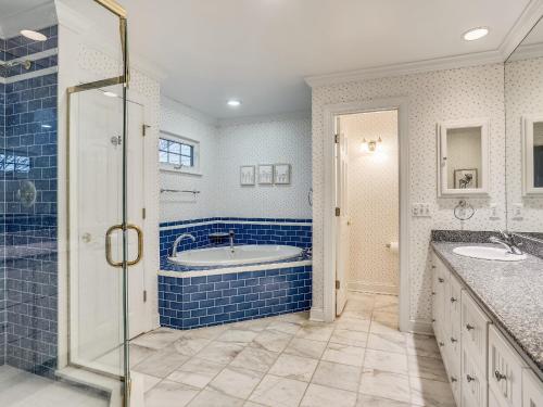 a blue bathroom with a tub and two sinks at Bay Breeze in Grasonville