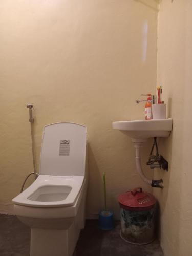 a bathroom with a toilet and a sink at Patience Airport cottages in Boma la Ngombe