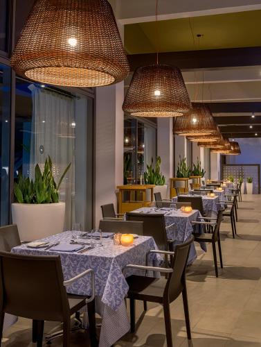 a row of tables in a restaurant with lights at Olympic Palace Hotel in Ixia