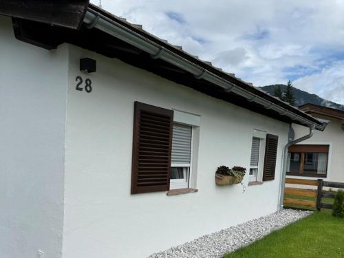 a white house with a window with a number eight at Tiroler Bergchalet bei Kitzbühel in Kirchdorf in Tirol