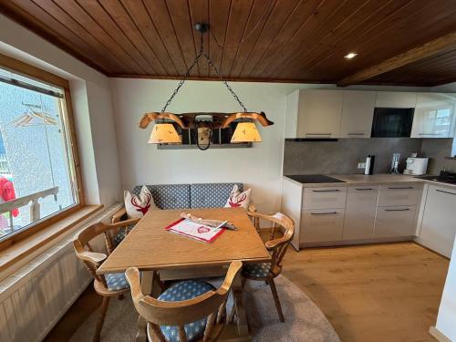 a kitchen with a wooden table with chairs and a chandelier at Tiroler Bergchalet bei Kitzbühel in Kirchdorf in Tirol