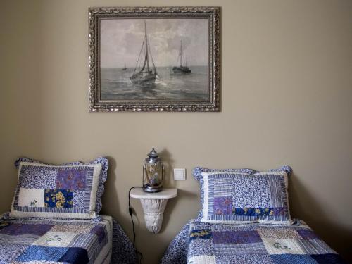 1 dormitorio con 2 camas y una foto en la pared en Casa do Souto, en Aldreu