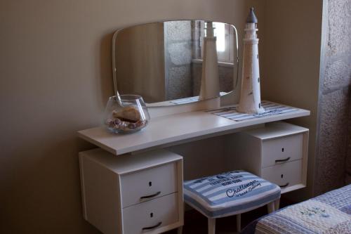 a white dressing table with a mirror and a stool at Casa do Souto in Aldreu