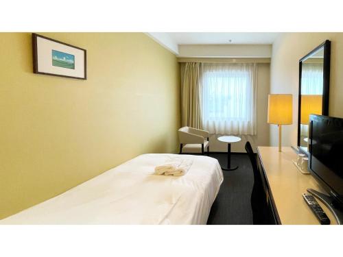 a hotel room with a bed and a flat screen tv at Smile Hotel Yonago - Vacation STAY 97652v in Yonago