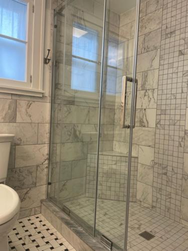 a shower with a glass door in a bathroom at The Lookout - Spacious Apartment in Superb Location in Burlington