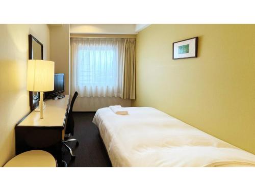 米子市にあるSmile Hotel Yonago - Vacation STAY 97649vのベッドと机と窓があるホテルの部屋