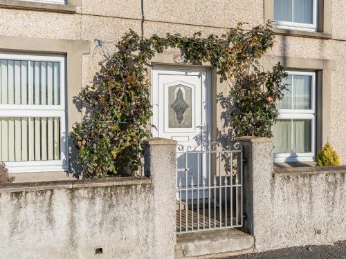 a house with a gate with plants on it at Rose Cottage in Pembrey