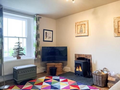 a living room with a television and a fireplace at Hepzibah Cottage in Broad Haven