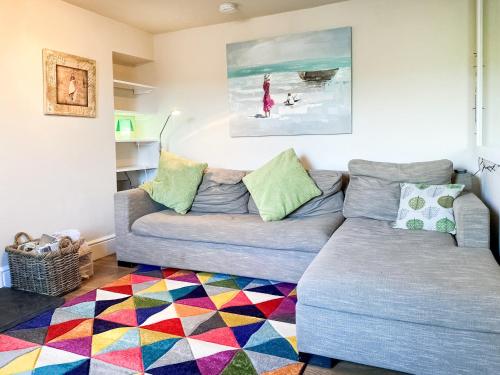 a living room with a couch and a colorful rug at Hepzibah Cottage in Broad Haven