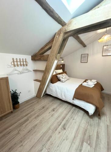 a bedroom with a bed and wooden floors at Serenity Appart', Les Clés de l'Espoir, proche Poitiers in Nieuil-lʼEspoir