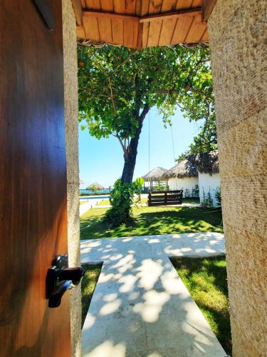 an open door to a yard with a tree at Serendipia Hotel Nizao in Nizao
