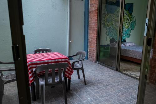 una mesa y sillas con un mantel a cuadros rojo y blanco en La casa del JAGUAR, en Tauramena