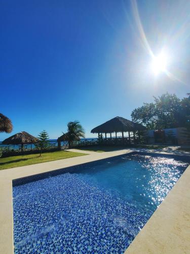 a swimming pool with a view of the ocean at Serendipia Hotel Nizao in Nizao