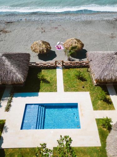 an aerial view of a swimming pool next to the beach at Serendipia Hotel Nizao in Nizao
