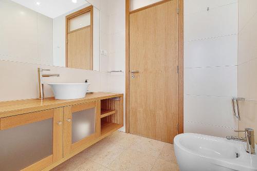 a bathroom with a sink and a toilet and a mirror at Som do Mar Luxury Ocean Front Villa, Prime Location! in Luz