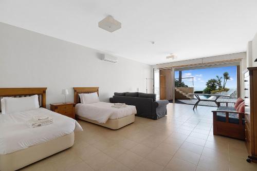 a bedroom with two beds and a living room at Som do Mar Luxury Ocean Front Villa, Prime Location! in Luz