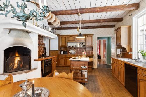 a kitchen with a fireplace and a wooden table at Private mansion for family, friends or colleagues 