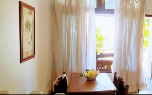 a dining room table with a vase of flowers on it at Pousada Luz do Porto in Porto De Galinhas