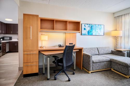 an office with a desk and a chair and a couch at TownePlace Suites by Marriott Mississauga-Airport Corporate Centre in Mississauga